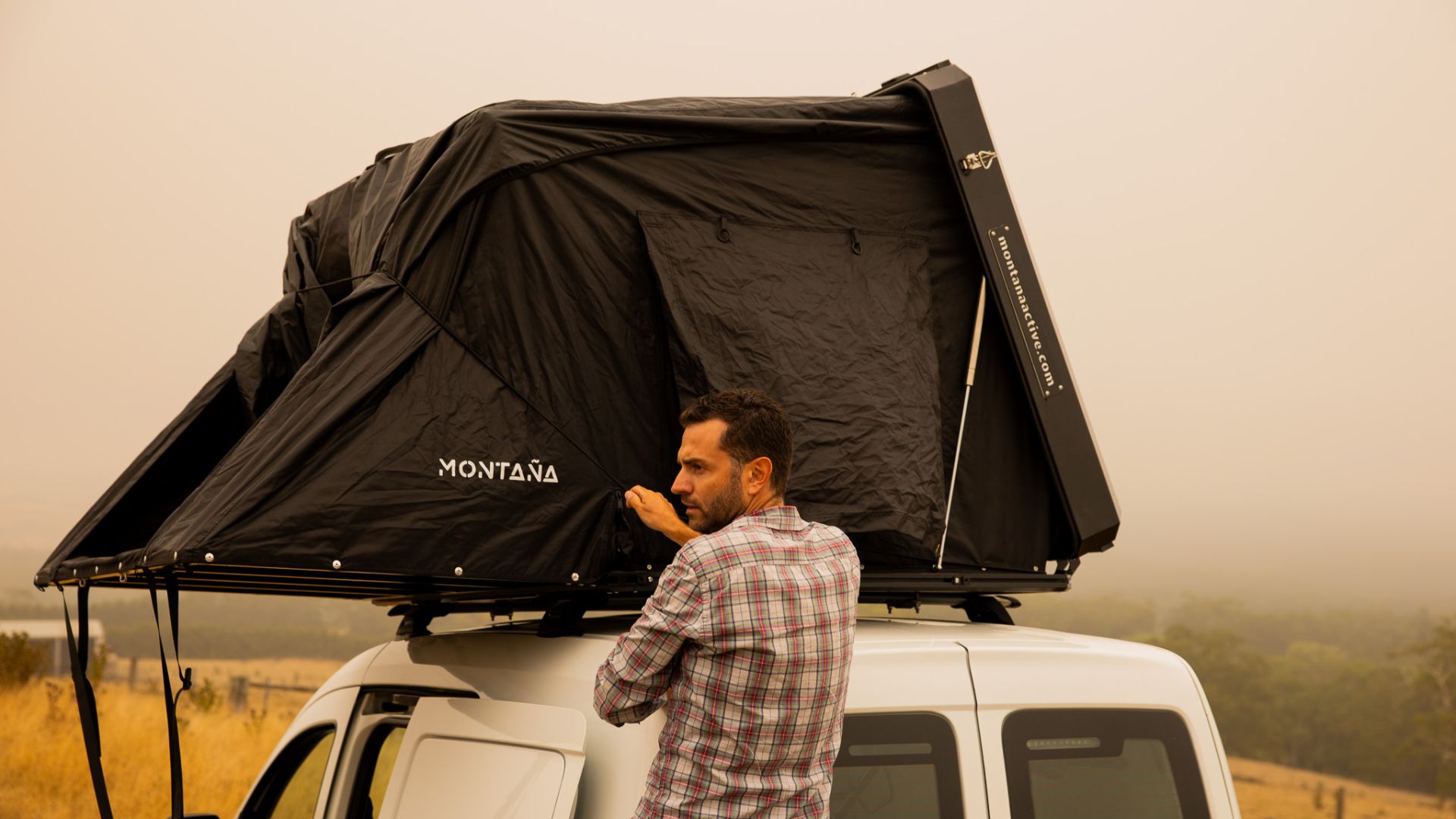 Tenda da tetto rigida Tre Cime montata su SUV durante un'avventura all'aria aperta.