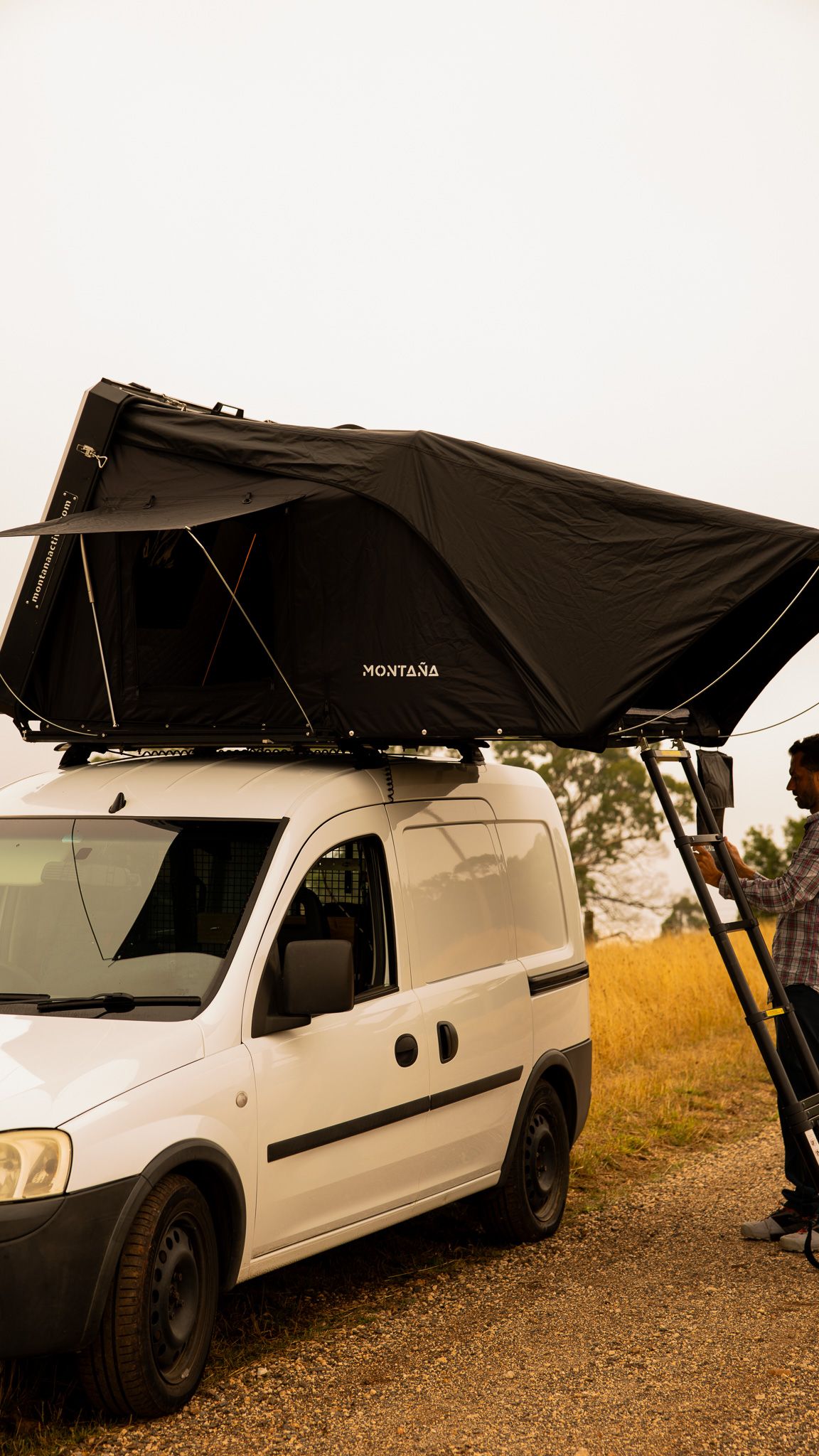 Tenda da tetto rigida Tre Cime montata su SUV durante un'avventura all'aria aperta.